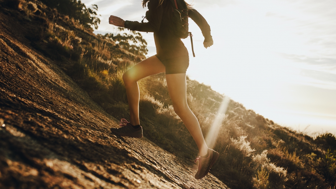 Woman running up a rocky mountain slope