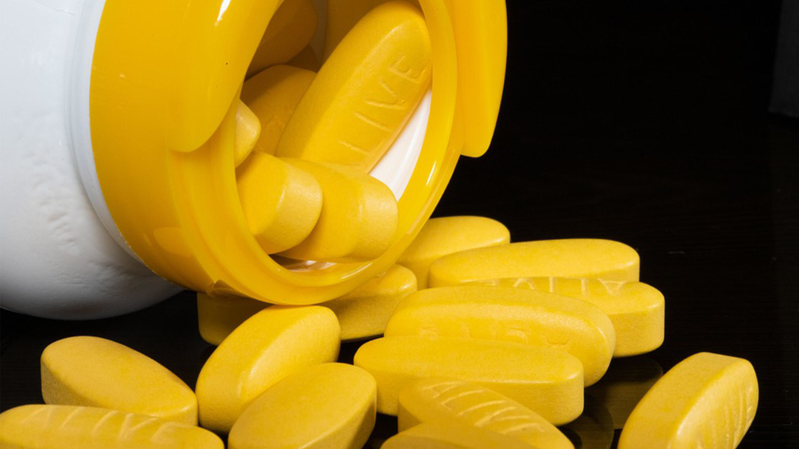 Vitamin B12 Gelbe Tabletten liegen vor einer Tablettendose